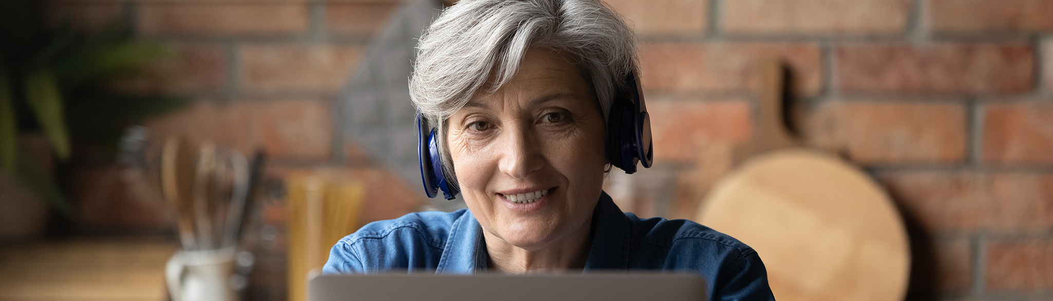 Kvinna med hörlurar framför datorn
